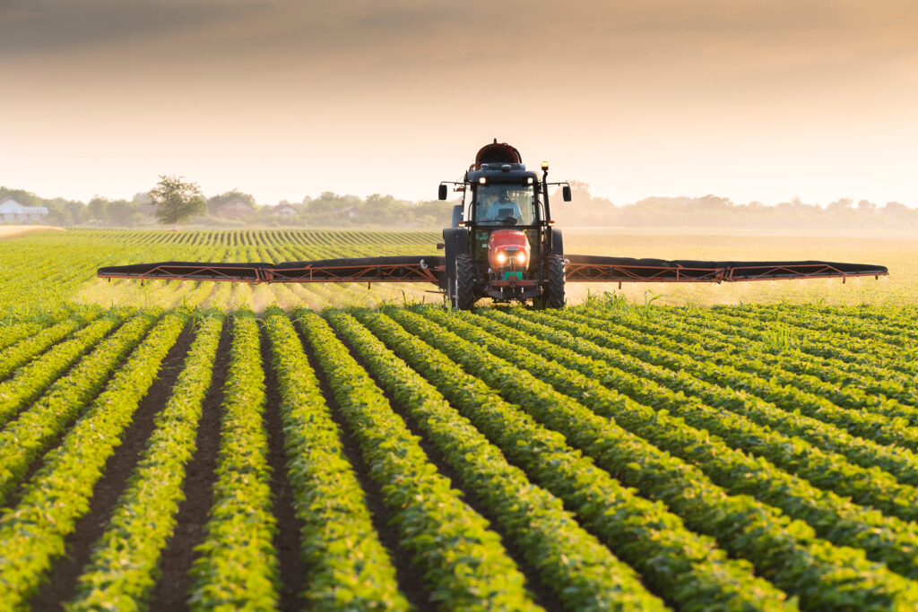 tractor spraying soybean field at spring